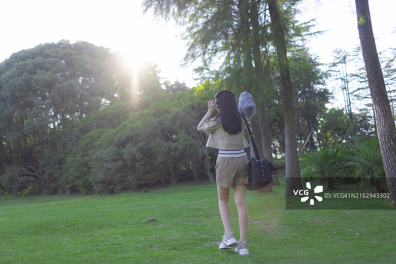 亚洲女性录音师使用枪式麦克风和挡风罩录制自然声音图片素材