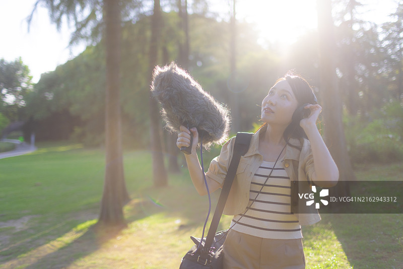 亚洲女性录音师使用枪式麦克风和挡风罩录制自然声音图片素材