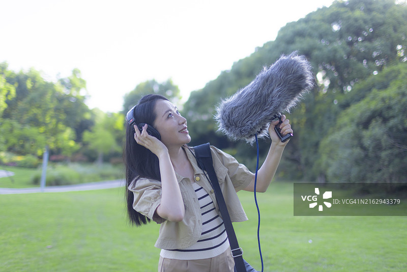 亚洲女性录音师使用枪式麦克风和挡风罩录制自然声音图片素材