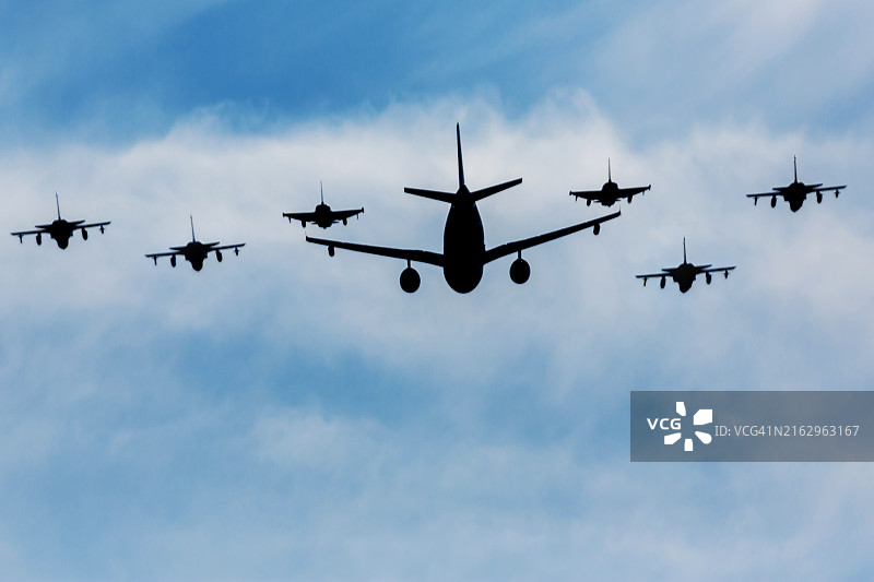 与六架战斗机护航的军用运输机图片素材