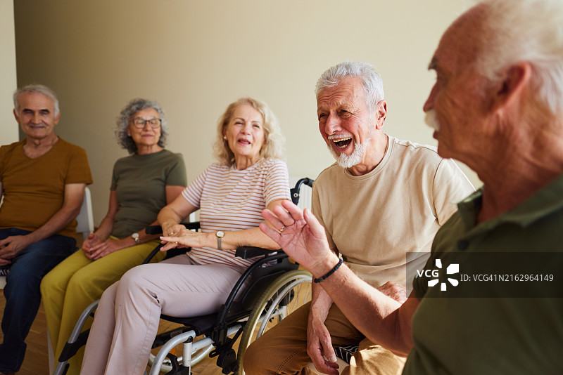 快乐的老年男人在小组治疗中与朋友们享受图片素材