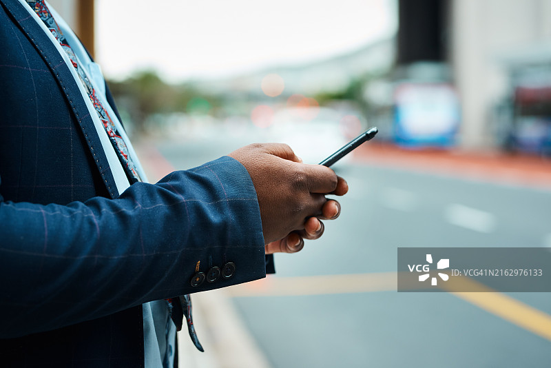 在城市街道上使用智能手机进行交流的西装革履的商人图片素材
