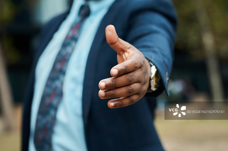 城市中一位黑人商人伸出手进行商务沟通的特写图片素材