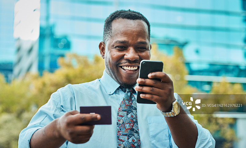 快乐商人使用手机和信用卡图片素材