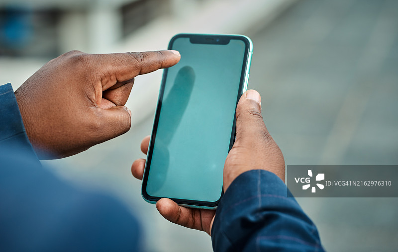 黑人男商人在城市里使用智能手机，手和移动设备的特写图片素材