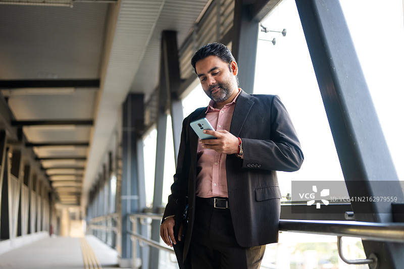 中年锡克教商人使用智能手机进行商务活动图片素材