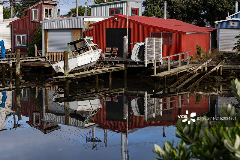 新西兰Petone，Hikoikoi保护区，哈特河河口：船只、船库与倒影图片素材