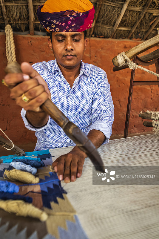 在拉贾斯坦邦编织纺织品（地毯）的印度男人图片素材