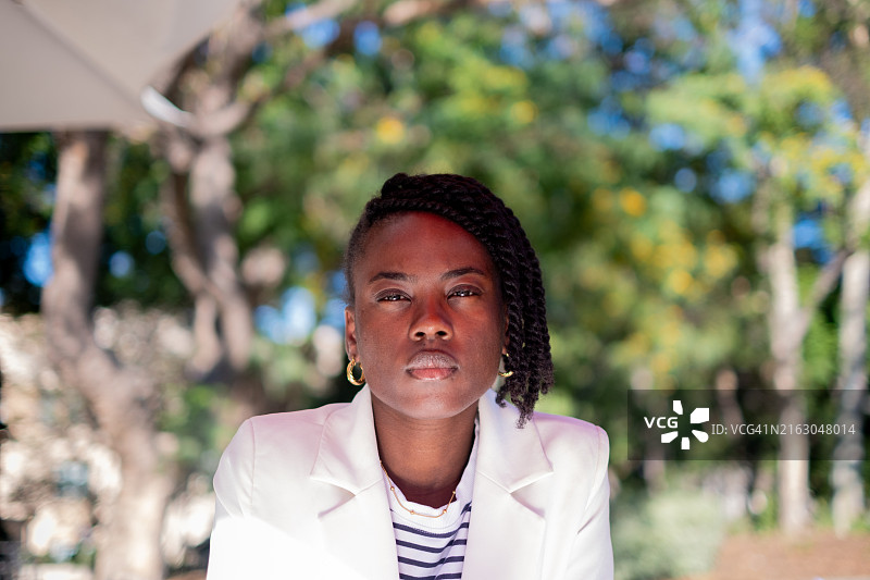 年轻女子坐在公园里的肖像，美国加利福尼亚州帕萨迪纳图片素材