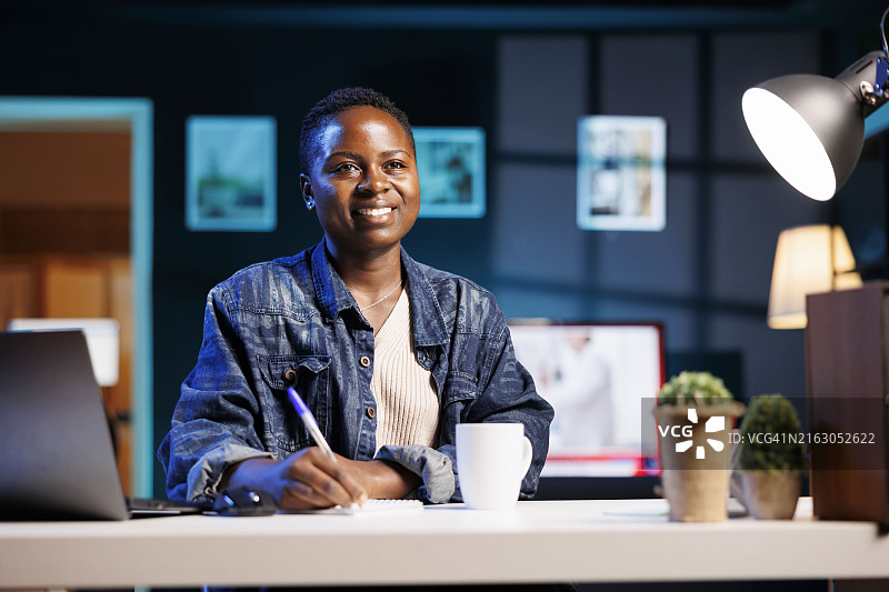 年轻女性游戏玩家戴耳机用笔记本电脑玩在线游戏。图片素材