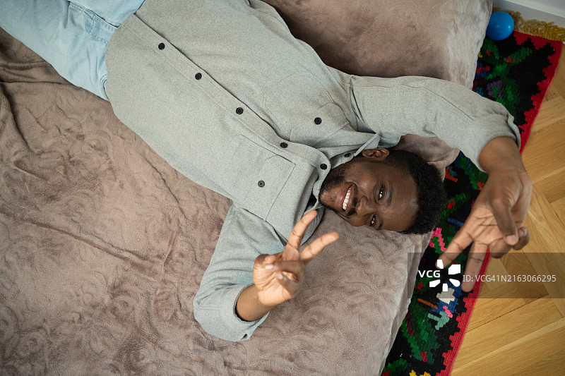 快乐的黑人穆斯林男子躺在床上图片素材