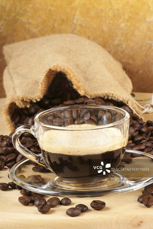 木桌上，咖啡豆旁，一杯意式浓缩咖啡特写图片素材