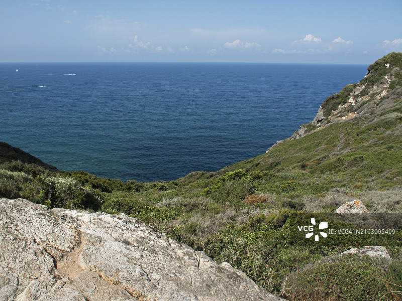 法国科西嘉岛阿雅克肖深蓝色大海边缘的岩石和植被图片素材