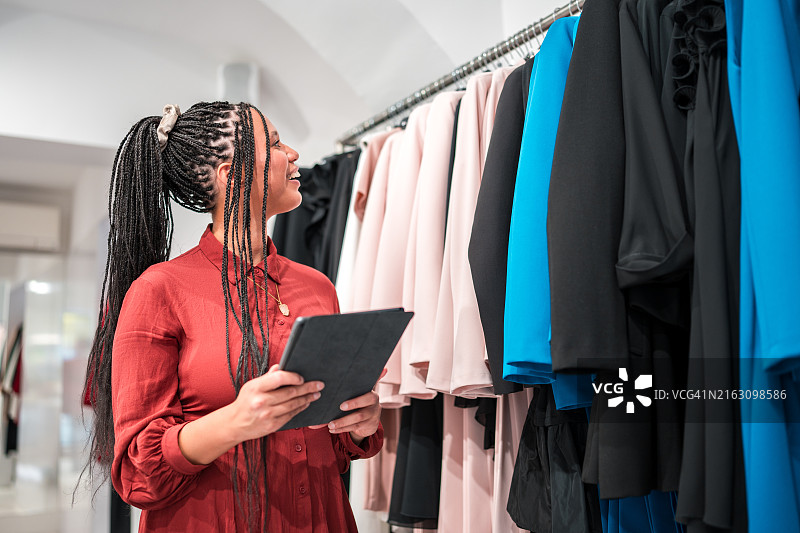 使用平板电脑检查库存的混血女小企业主图片素材