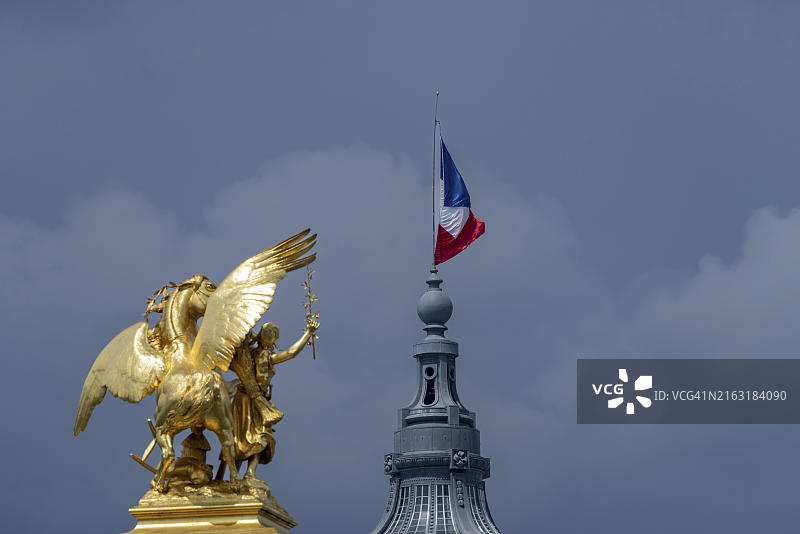 亚历山大三世桥上的农业女神雕像，背景是法国国旗和巴黎大皇宫的穹顶图片素材