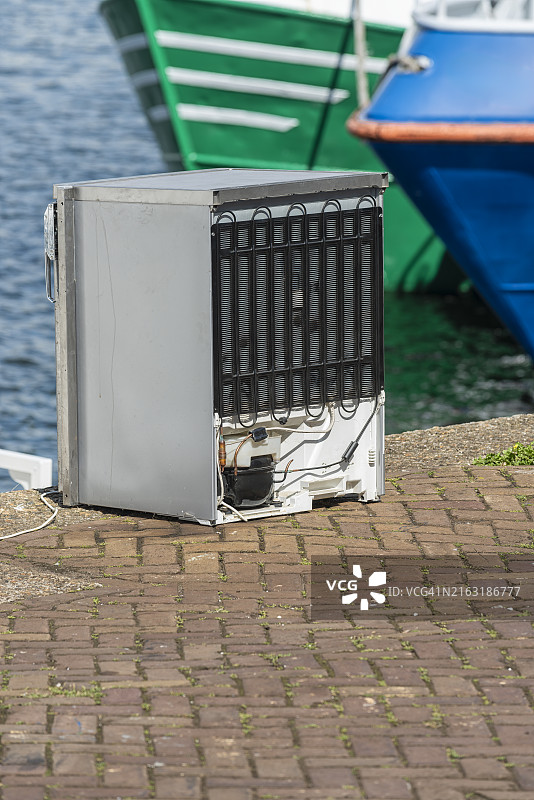 白色冰箱被丢弃在户外图片素材