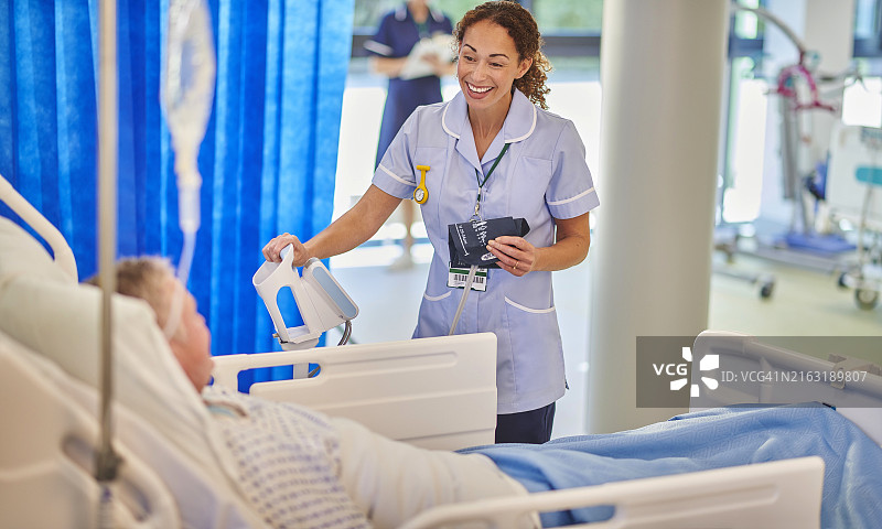微笑的护士在医院病房里和病人聊天图片素材