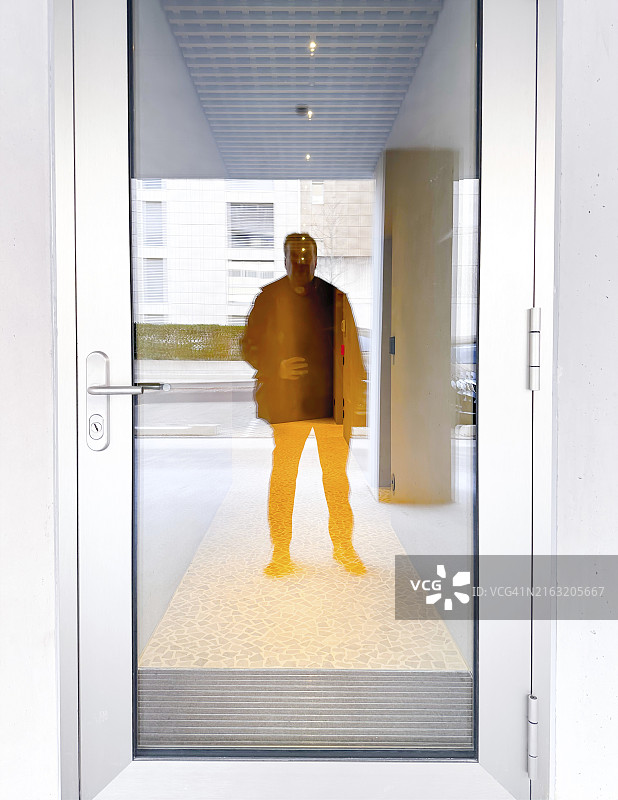 在瑞士的玻璃门中反射的男人图片素材