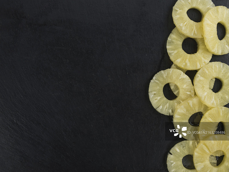 复古石板上的新鲜蜜饯菠萝圈特写镜头图片素材