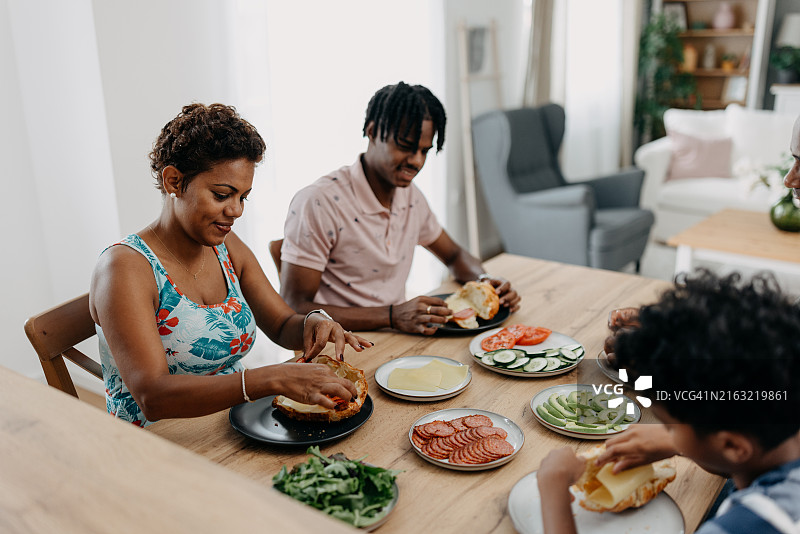 母子在餐桌旁准备三明治图片素材