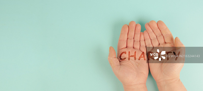 手与“慈善”字样，支持和帮助概念，社会问题，人道主义援助图片素材