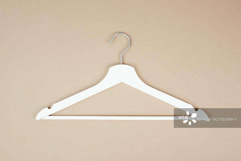 粉色背景上的白色衣架，时装店，极简主义服装，折扣促销图片素材