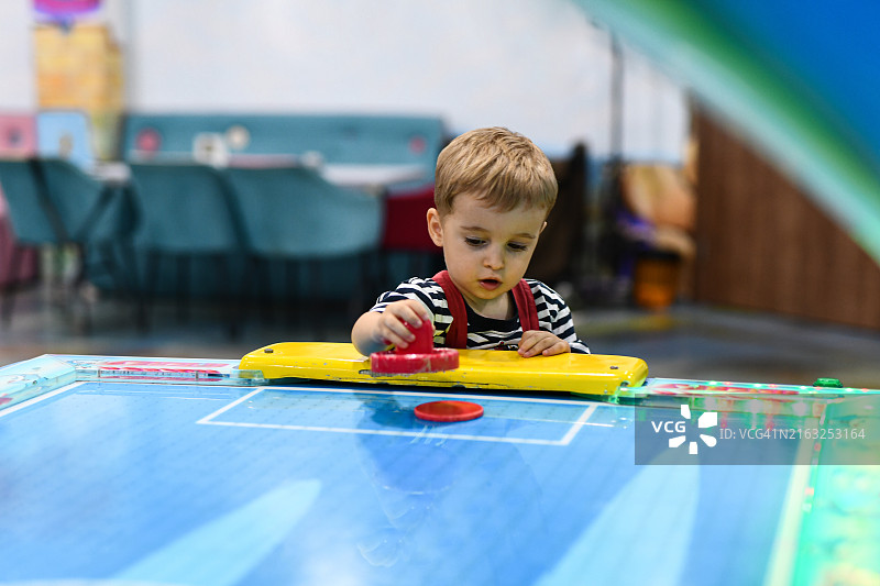 幼儿学习如何推动空气曲棍球盘图片素材