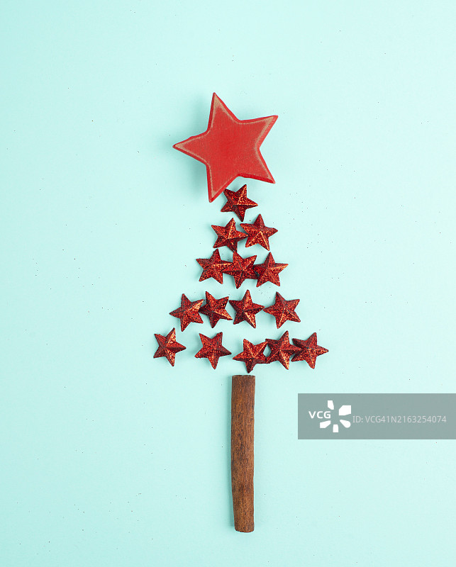 用红色星星和肉桂棒作为树干制成的圣诞树，带有复制空间的冬季节日贺卡图片素材