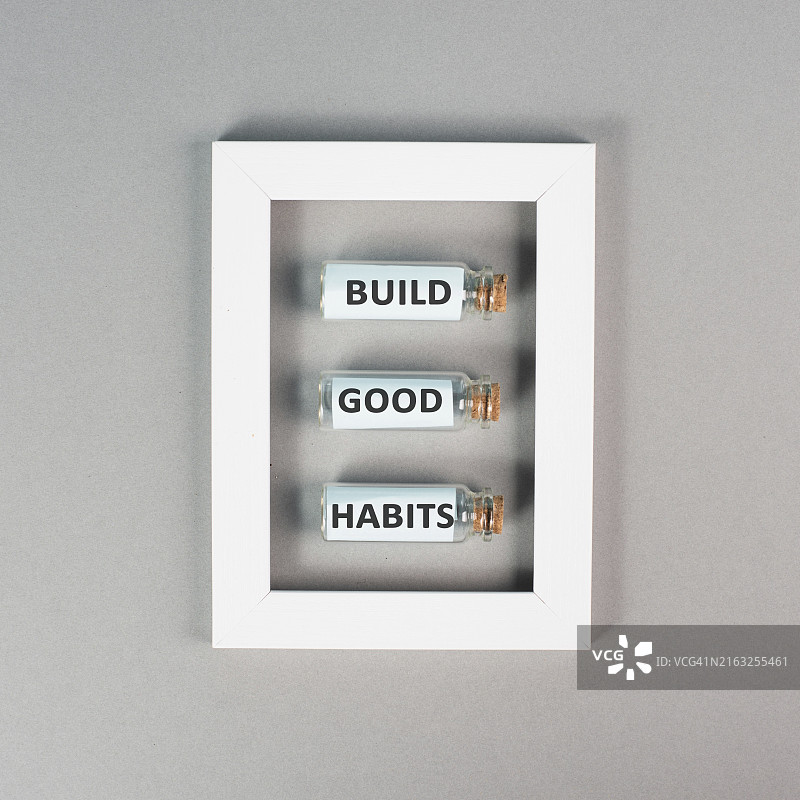 “培养好习惯”文字，站立在相框中的玻璃瓶上，改变生活方式，健康积极的态度，励志概念图片素材