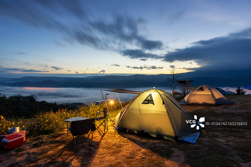 泰国日落时分薄雾笼罩的草地上露营地的旅行帐篷图片素材