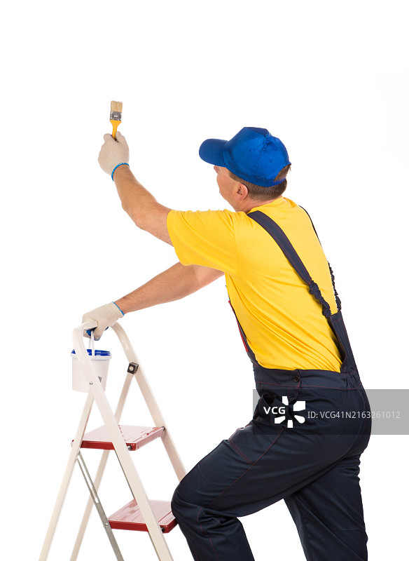 男人在梯子上粉刷墙壁的侧视图，白色背景图片素材