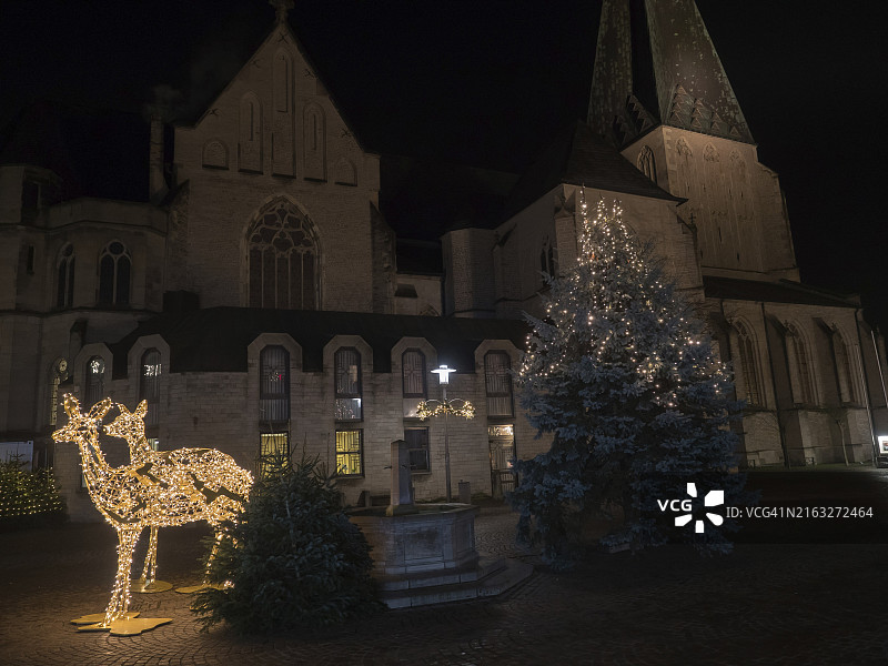 夜晚装饰的教堂，带有照明的驯鹿和圣诞树，位于德国北莱茵-威斯特法伦州博霍尔特图片素材
