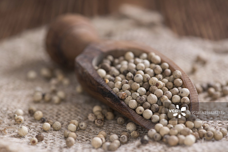 木质背景上的白胡椒粒（特写）图片素材