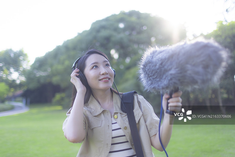 亚洲女性录音师使用枪式麦克风和挡风罩录制自然声音图片素材