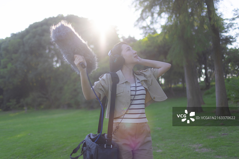 亚洲女性录音师使用枪式麦克风和挡风罩录制自然声音图片素材