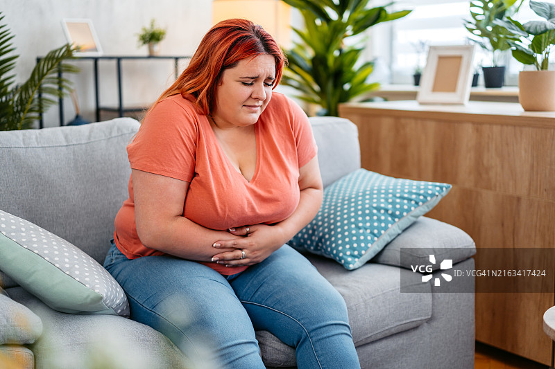 年轻女人在家胃痛图片素材