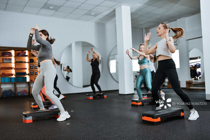 用踏步机锻炼爆发力的运动型女人们图片素材