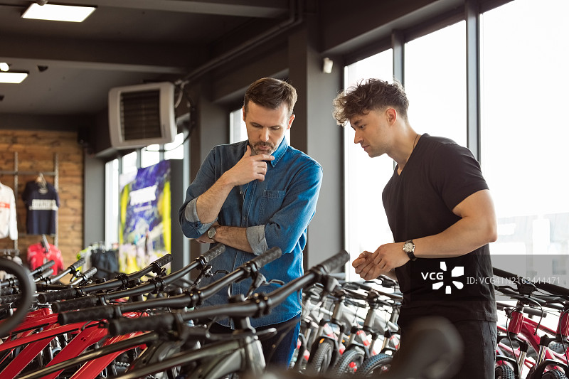 男子在自行车店观看自行车图片素材