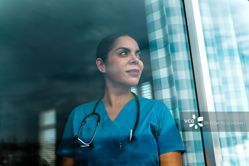 女护士若有所思地看着窗外图片素材