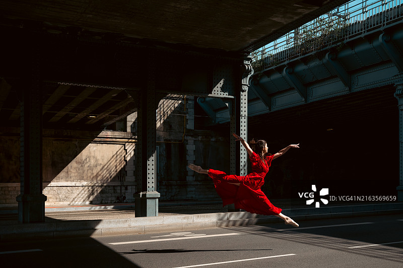 穿着红色长裙在街上跳芭蕾舞的女芭蕾舞演员图片素材