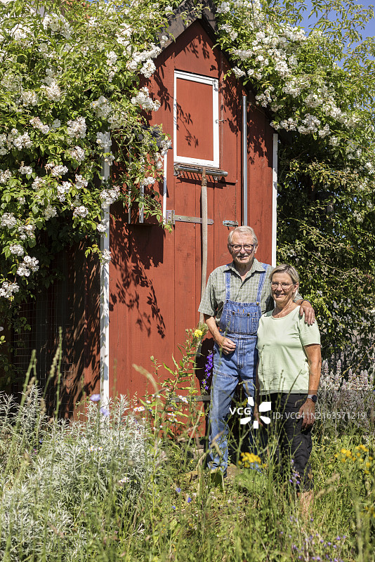 年长夫妇站在花园棚屋旁图片素材