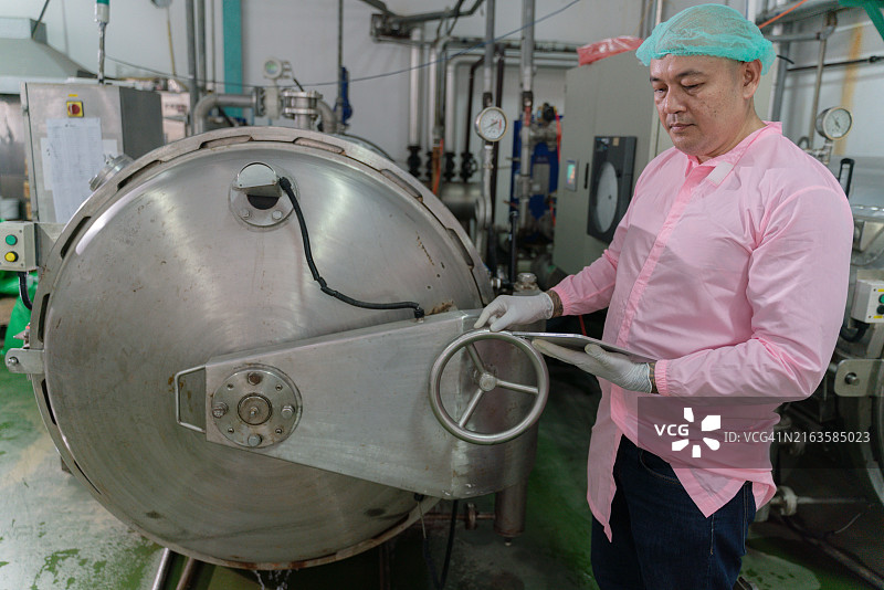 穿着粉色衬衫的男人正在操作机器图片素材