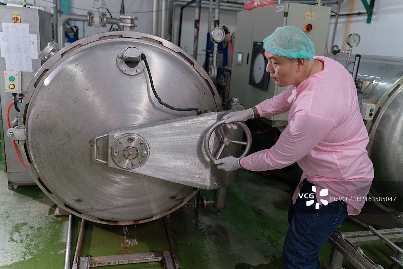 身穿粉色衬衫的男子正在打开机器图片素材