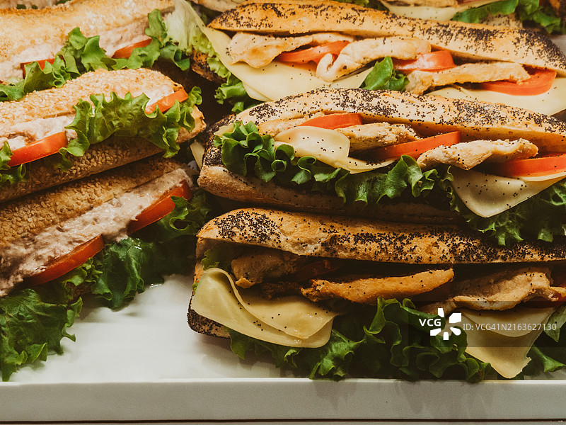 展示各种鸡肉三明治，配有奶酪、西红柿和生菜图片素材