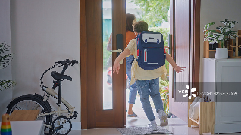 男孩兴高采烈地跑出家门去上学图片素材