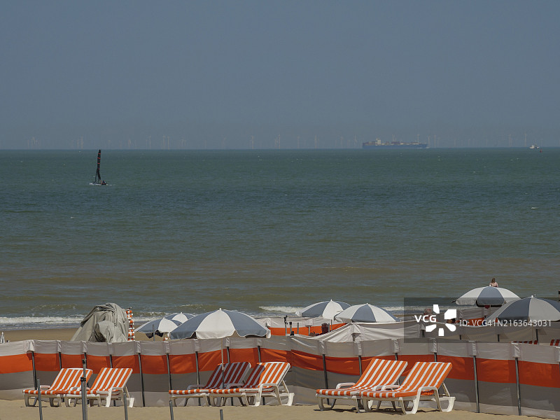 比利时代汉沙滩，橙白沙滩椅与帆船图片素材