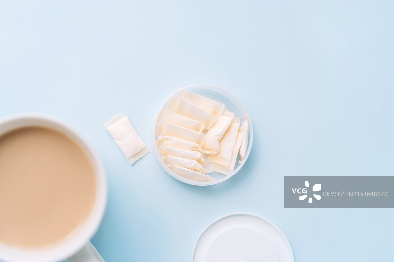 蓝色背景下装有鼻烟袋和咖啡杯的敞口罐子图片素材