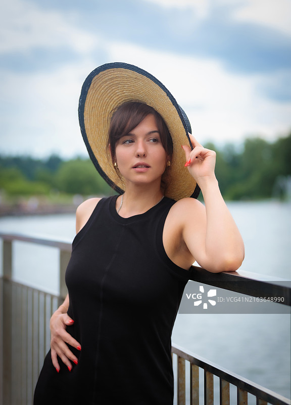 戴帽女子在池塘边的人物肖像图片素材