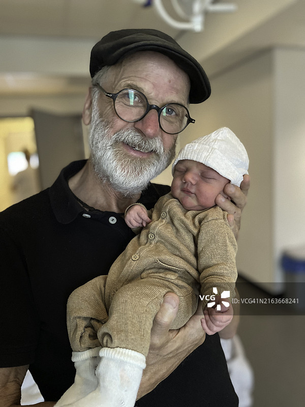 自豪的爷爷展示小孙子图片素材