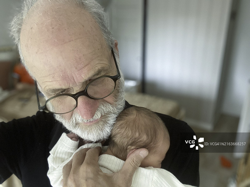 自豪的祖父抱着孙子图片素材
